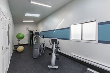 our gym has a variety of exercise equipment and windows at The Lakes Apartments, Washington